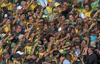 El presidente de Brasil, Jair Bolsonaro (en la esquina de la derecha), es saludado por sus seguidores durante un acto en Copacabana, Río de Janeiro. (AFP)