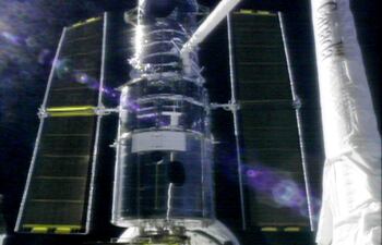 Una imagen del telescopio espacial Hubble tomada desde el transbordador espacial Discovery, cuando en 1999 su tripulación lo sujetó para realizar unas reparaciones en el aparato.