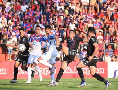 Carrizo trata de rematar al arco ante la defensa de los rojos