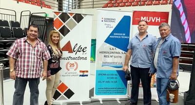 Responsables de la empresa Alpe SA posan junto a los banners de la firma, del SAT Hidrocontrol y del Ministerio de Urbanismo, imagen difundida en las redes sociales. Las empresas se unieron para construir viviendas sociales, el año pasado.