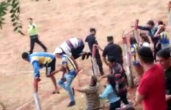 Momento en que los simpatizantes del equipo visitante invaden el campo de juego.