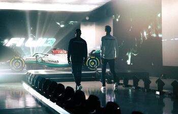 Lewis Hamilton (i) y George Russell caminan hacia el nuevo monoplaza de la Mercedes para la temporada 2022 de la F1.