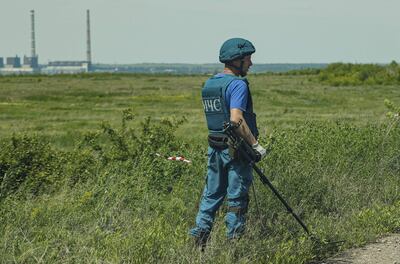 Un funcionario de la autoproclamada República Popular de Donetsk busca minas antipersonales en un camino cerca de la localidad de Svitlodarsk, Ucrania.