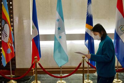 Una mujer camina junto a una bandera de Honduras en el Ministerio de Relaciones Exteriores de Taiwán, en Taipei.