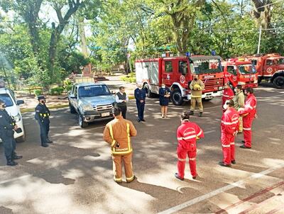 Bomberos,  policías y el Pbro.  Cirilo Martínez durante el acto.