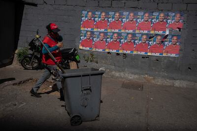 Una mujer camina frente propaganda de un candidato chavista para las elecciones locales, en Caracas.