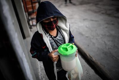 Un niño muestra una jarra de leche que recibió en un comedor comunitario, en Buenos Aires (Argentina).
