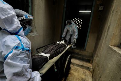 Los trabajadores sanitarios indios manipulan el cuerpo de un paciente, que murió de Covid-19, en el hospital Covid-19 de Kolkata, India oriental, el 07 de mayo de 2021.