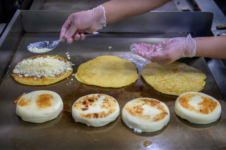 Un cocinero prepara arepas en la cocina de Arepa Lady en Queens.
