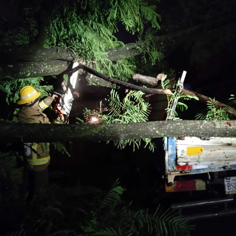 Arduo trabajo de los bomberos voluntarios para asistir a los afectados por el temporal del miércoles. En la foto, momentos del rescate de un vehículo que fue afectado por la caída de un árbol.
