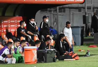 Julio César Cáceres (remera blanca) en el banco de suplentes de Olimpia durante el partido de Copa Libertadores 2022 contra Colón de Santa Fe en el estadio Defensores del Chaco.