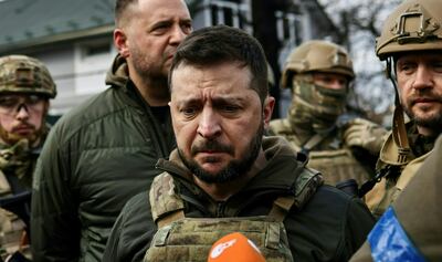 El presidente de Ucrania Volodymyr Zelensky (C)
