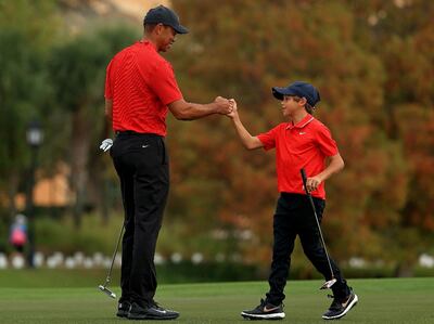 Tiger y su hijo Charlie  chocan el puño en el hoyo 18.