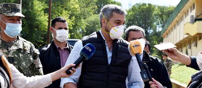 Mario Abdo (c) dialoga con los periodistas, tras saludar al grupo de paraguayos que cumplieron la cuarentena en la Academil.