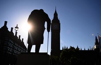 El sol se eleva detrás de la estatua del exprimer ministro británico Winston Churchill junto al Parlamento en Londres.