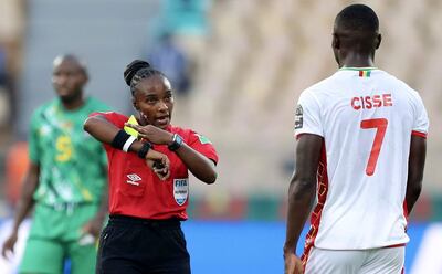 La ruandesa Salima Rhadia Mukansanga, árbitra internacional de FIFA, le saca tarjeta amarilla al guineano Ibrahima Cisse, durante el partido de ayer ante Zimbabue.