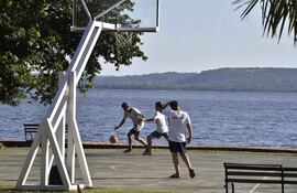 Con el lago de fondo, estos amigos disfrutan de un partido de basquet.