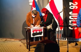 El senador Carlos Filizzola firma el acta de relanzamiento de la Coordinadora de Solidaridad Paraguay-Cuba, el lunes en la Embajada cubana en Asunción.