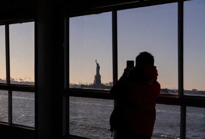 La pasajera de un ferry toma una foto de la Estatua de la Libertad, en Nueva York.