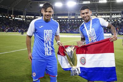 Ángel Romero y Juan Escobar, con el trofeo de la Supercopa de México y la bandera paraguaya.