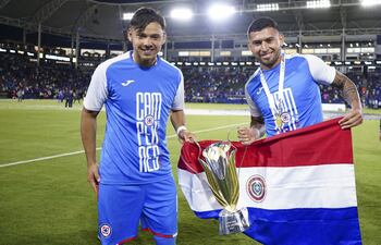 Ángel Romero y Juan Escobar, con el trofeo de la Supercopa de México y la bandera paraguaya.