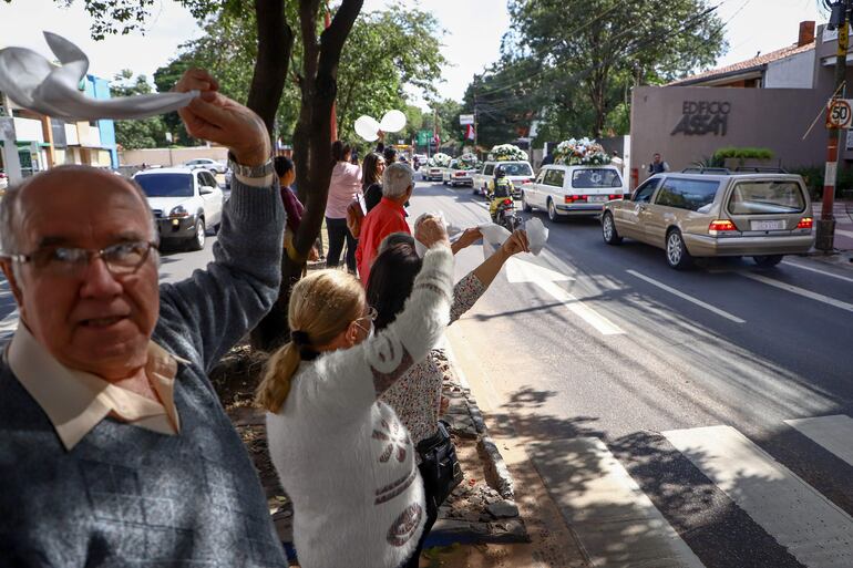 Ciudadanos ondean hoy pañuelos y globos blancos en homenaje al asesinado fiscal Marcelo Pecci, mientras su cortejo fúnebre abandona el salón velatorio Memorial, en Asunción (Paraguay). 
