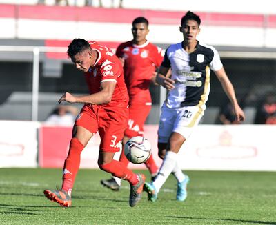 El zaguero central Manuel Romero aborta el peligro ante la presencia cercana del atacante Gustavo Aguilar.