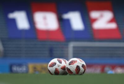 Cuatro pelotas sobre el césped de La Nueva Olla con la bandera azulgrana de 1912, año de fundación de Cerro Porteño.