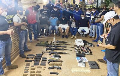 Los  detenidos junto a las armas y otras evidencias incautadas por los antidrogas.