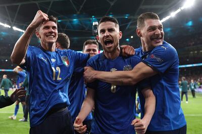 Jorginho (centro) celebra su gol, el que definió la tanda de penales. Lo felicitan Matteo Pessina (i) y Andrea Belotti.