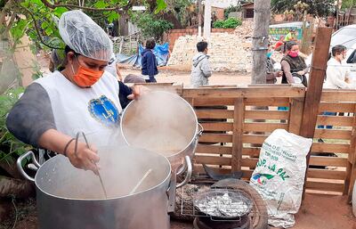Una de las voluntarias preparando el alimento para familias de escasos recursos que viven en el Asentamiento Villa Angélica de Lambaré.