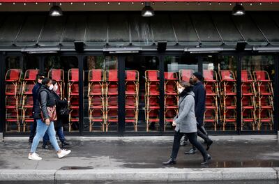 Personas con mascarillas protectoras pasan frente a un restaurante cerrado debido a las medidas restrictivas tomadas para frenar la propagación del covid-19, en París.