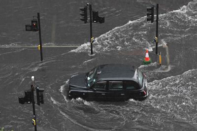 Un taxi londinense atraviesa el agua en una carretera inundada en el distrito de Nine Elms de Londres ayer, domingo.