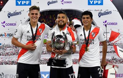 Robert Rojas (d) sonriente con Federico Girotti y Paulo Díaz, quien exhibe la Supercopa.