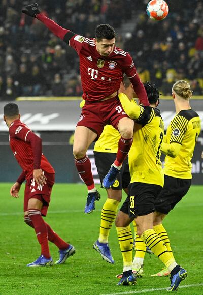 Robert Lewandowski salta en procura del balón ante la marca de tres jugadores del Dortmund.