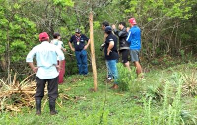 Un grupo de ocupantes del campo comunal conversan con los fiscalizadores del Mades.