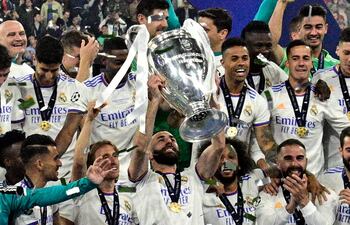 Karim Benzema, levantando el trofeo, es uno de los nueve jugadores del Real Madrid que sumó ayer su quinto título en la Champions.