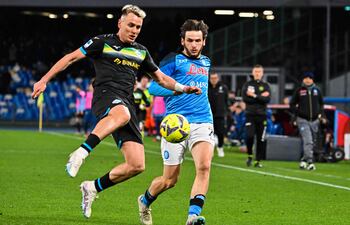 Patric (i), defensor español de Lazio, se dispone a despejar el balón ante la presencia de Khvicha Kvaratskhelia, delantero georgiano del Napoli, durante el partido que disputaron ayer.