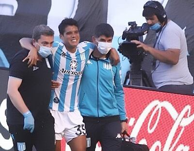 Ayudado por los de la sanidad de Racing se retira del campo de juego Lorenzo Melgarejo en el partido de Racing-Tucumán.