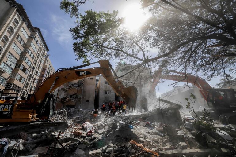 Una excavadora despeja escombros de un edificio destruido por ataques israelíes en un distrito residencial de la Ciudad de Gaza, este domingo.