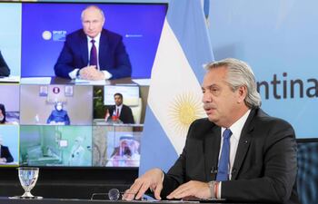 Handout photo released by Argentina's Presidency showing Argentine President Alberto Fernandez (C) talking in a video conference with Russian President Vladimir Putin to announce the beginning of the local production of Sputnik V vaccine at the Olivos Presidential residence in Olivos, Buenos Aires on June 4, 2021. - The Argentine private laboratory Richmond will be in charge of the fragmentation and packaging of the vaccine, with an initial production capacity of 1,000,000 doses per month, which it expects to increase to 5,000,000 over a period of one year. (Photo by Handout / Argentinian Presidency / AFP) / RESTRICTED TO EDITORIAL USE - MANDATORY CREDIT "AFP PHOTO / ARGENTINIAN PRESIDENCY / ESTEBAN COLLAZO " - NO MARKETING - NO ADVERTISING CAMPAIGNS - DISTRIBUTED AS A SERVICE TO CLIENTS