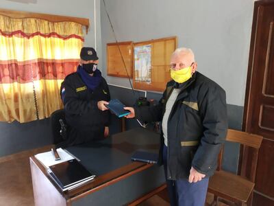 El pastor Román Lozko regalando una biblia a un personal de la comisaría de Fram.