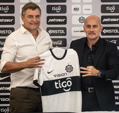 Diego Aguirre (57 años) y el presidente Miguel Cardona (56) con los tres dedos que simbolizan la cantidad de títulos ganados por Olimpia en la Libertadores.