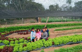 Fabio Villalba en su huerta comunitaria en compañía de sus hijos Alex, Fabiana y Fabiano para quienes trabaja en una comunidad de Altos.