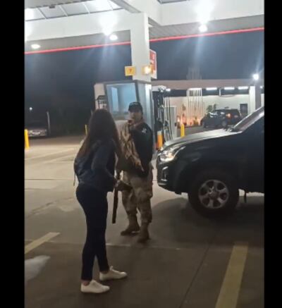 Momento en que un agente de GEO rocía con gas pimienta a una joven, en un operativo llevado a cabo en una estación de servicio de Luque.