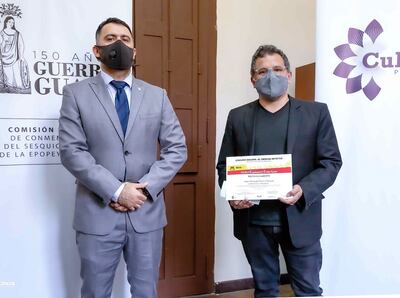 Hugo Ferreira sostiene su mención de ganador, acompañado de Juan Marcelo Cuenca.