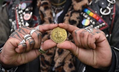 Un hombre sostiene una representación física del bitcóin.