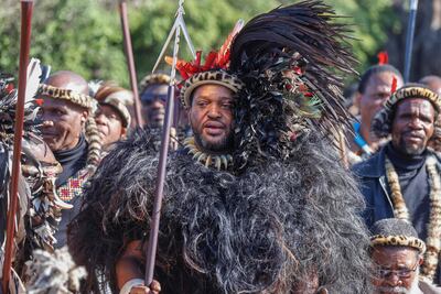 El rey de la nación amazulu, Misuzulu kaZwelithini (centro), sostiene una lanza mientras canta con Amabutho (regimientos zulúes) durante su coronación en el Palacio Real KwaKhangelamankengane en Kwa-Nongoma, 300 km al norte de Durban.