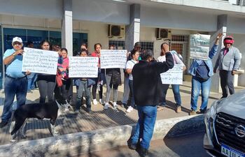 Reducido grupo de vecinos del territorio social Nuevo Renacer de la ciudad de San Antonio se manifestó hoy frente a la municipalidad local para exigir el reconocimiento de una comisión vecinal provivienda.
