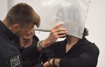 Un miembro del clan Remmo se cubre la cara al llegar al juicio donde se conocería el veredicto por el robo en el museo de Dresde, en Alemania.